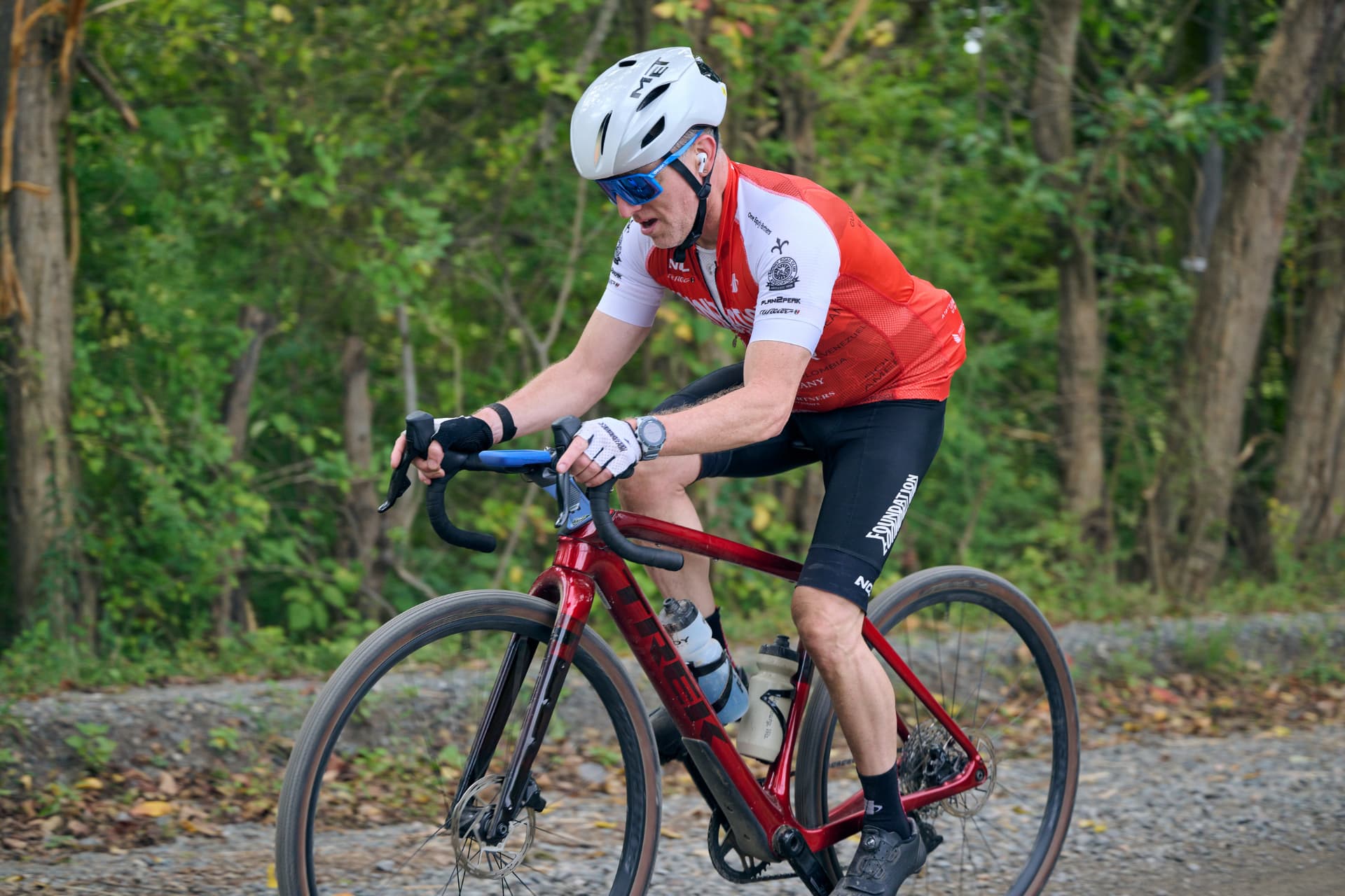 Rider in a red and white kit on a dirt road